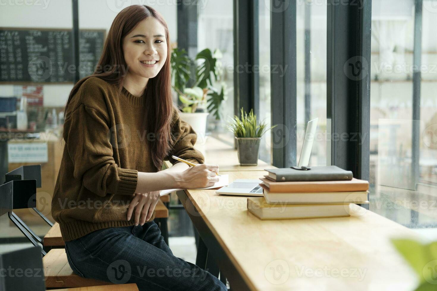 Young collage student using computer and mobile device studying online. photo