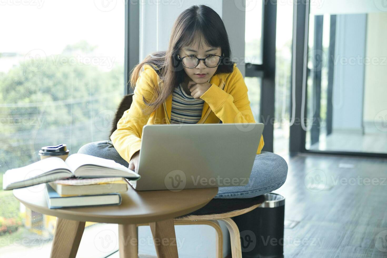 Young collage student using computer and mobile device studying online. photo