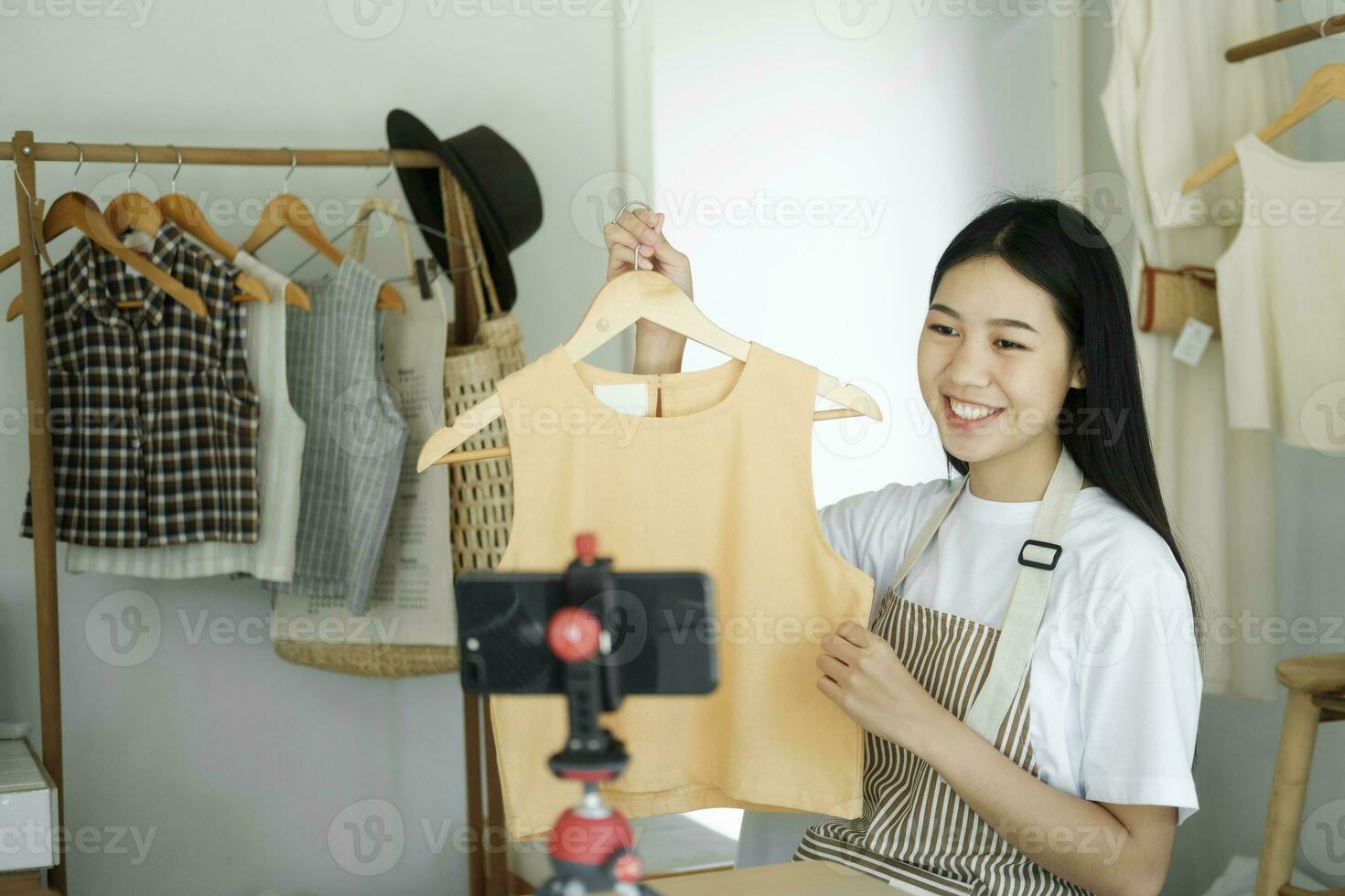 joven asiático mujer de negocios Moda blogger demostración paño con sonriente rostro. foto