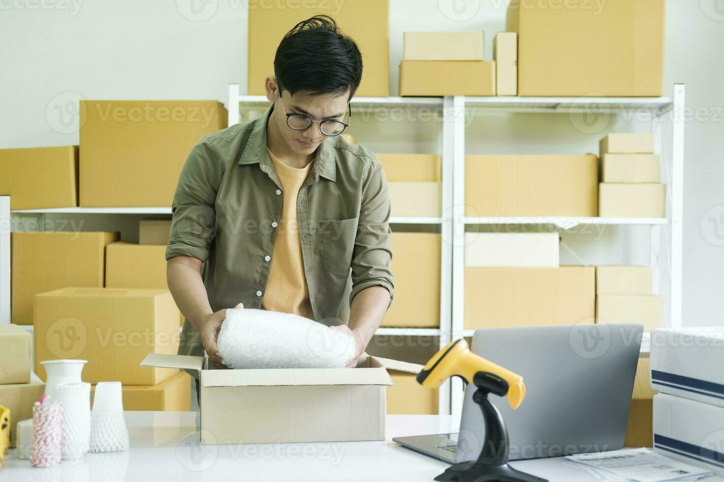 Young entrepreneur packing product in mailing box for shipping. photo