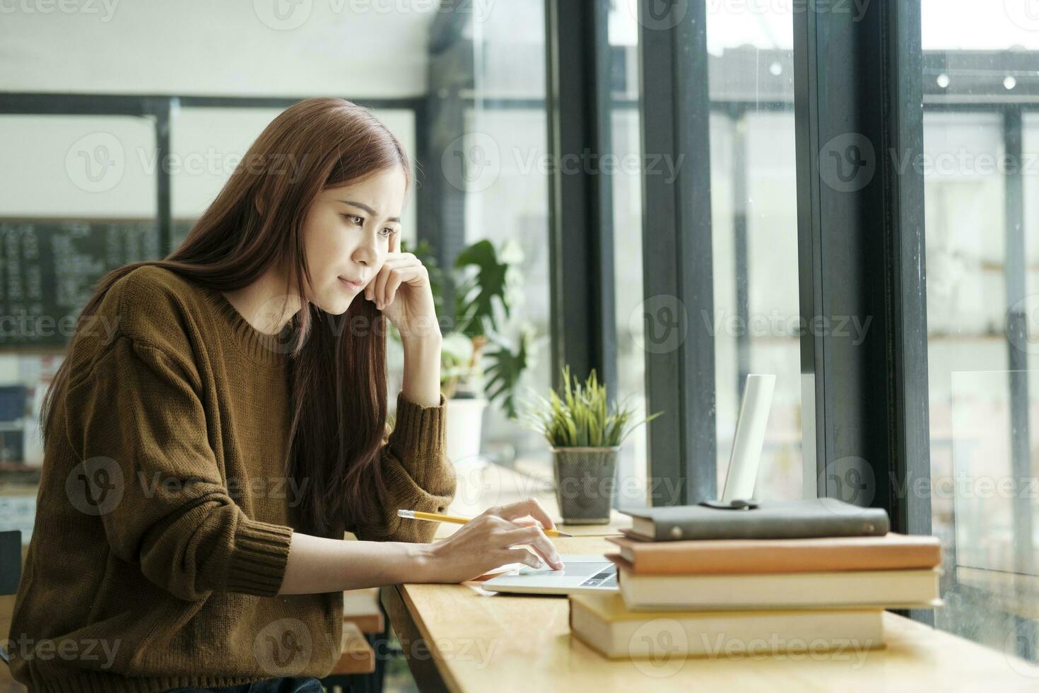 Young collage student using computer and mobile device studying online. photo
