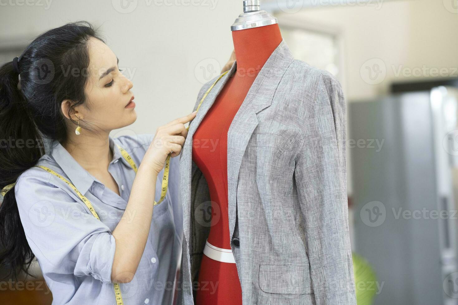 Fashion designer working on dress on dummy. photo