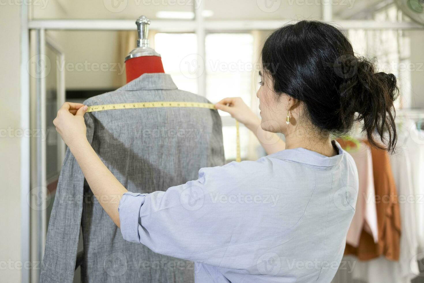 Fashion designer working on dress on dummy. photo