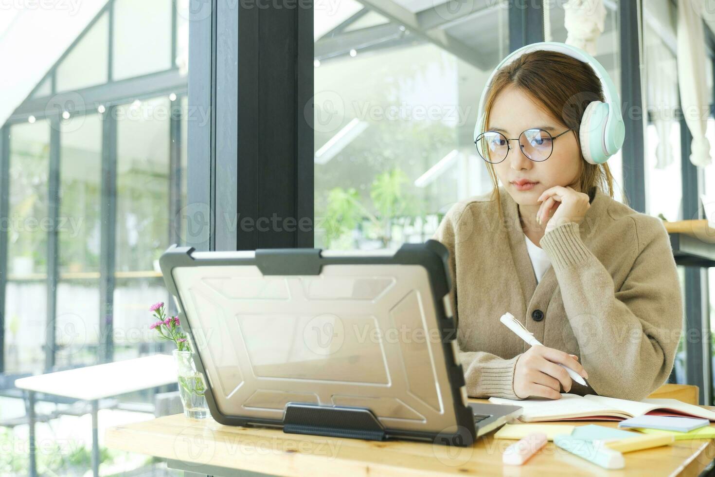 Young collage student using computer and mobile device studying online. photo
