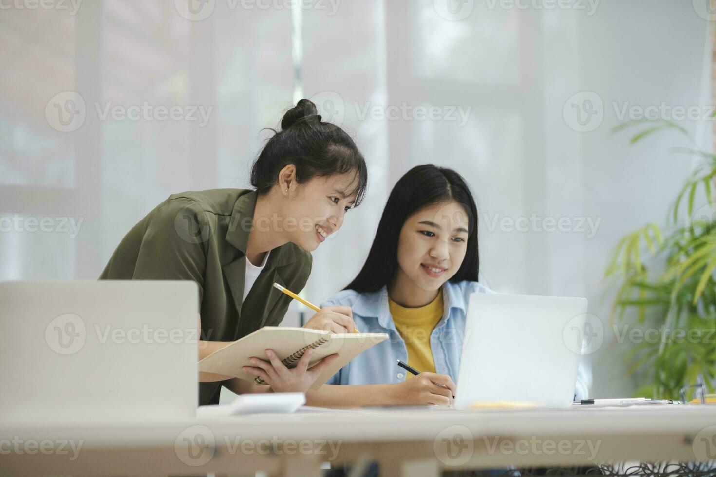 joven asiático Universidad estudiantes estudiando aprendizaje discutir trabajando en computadora. foto