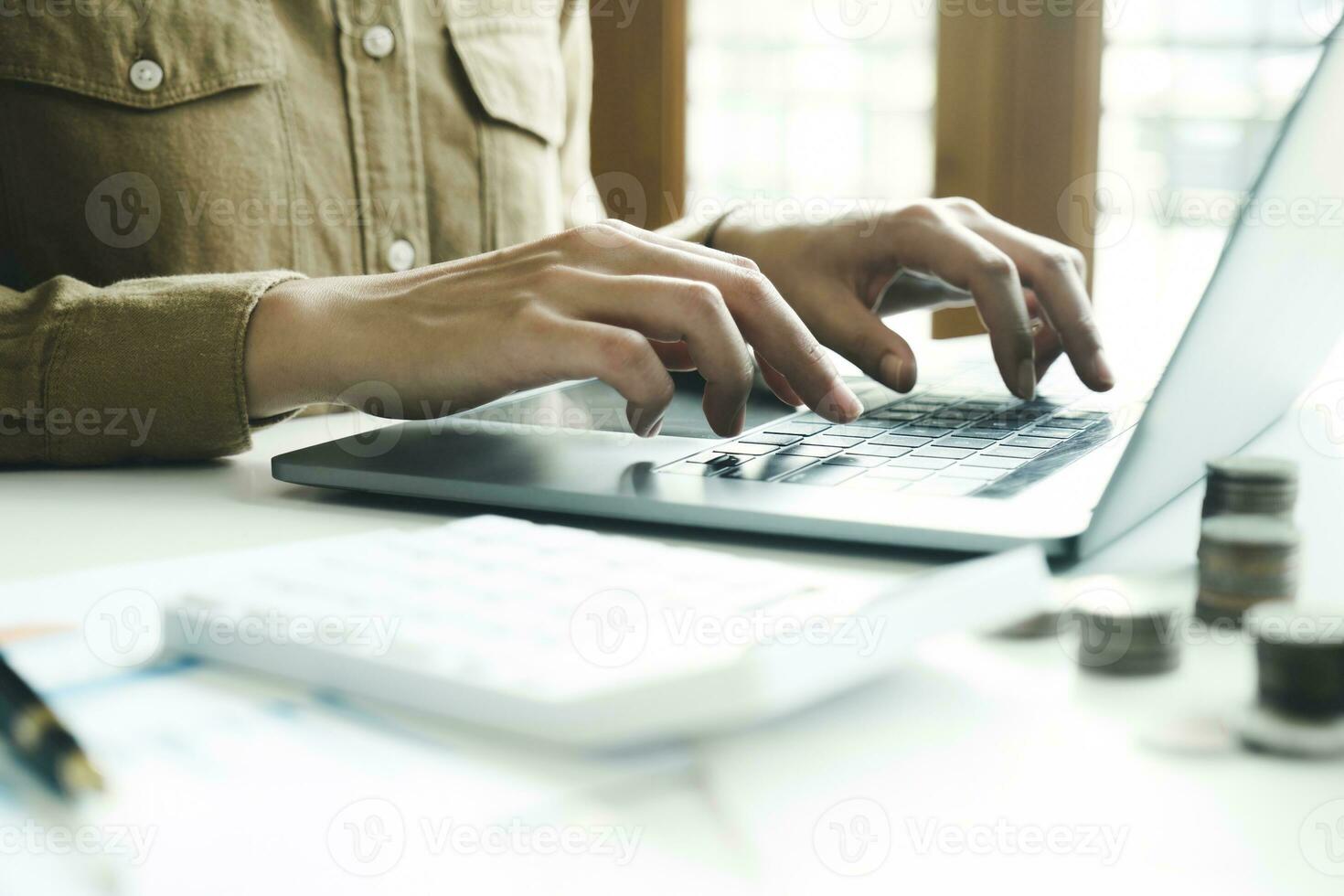 Woman accountant working on laptop computer while counting taxes online. photo