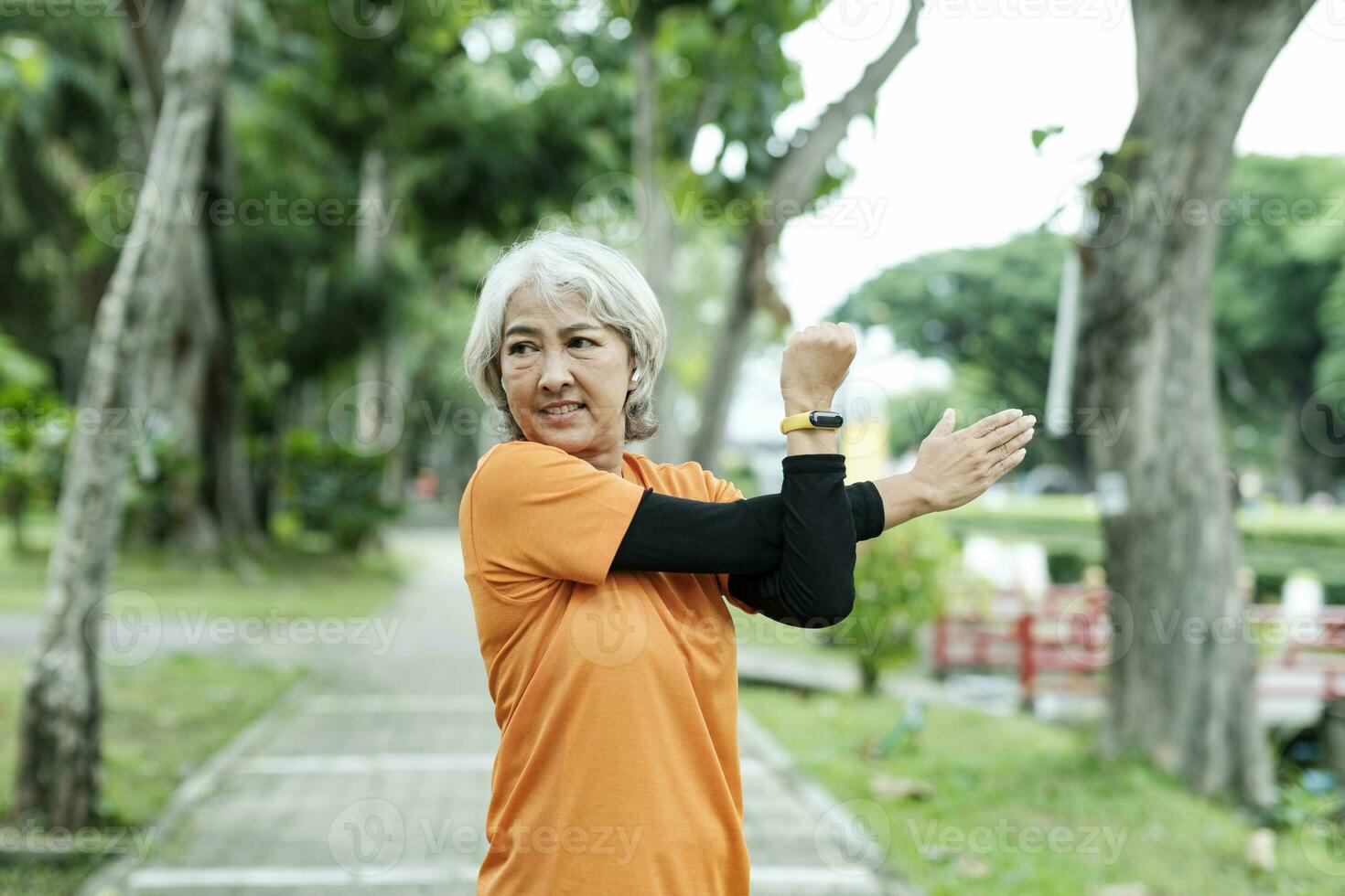 atlético mayor mujer extensión brazo en parque. foto