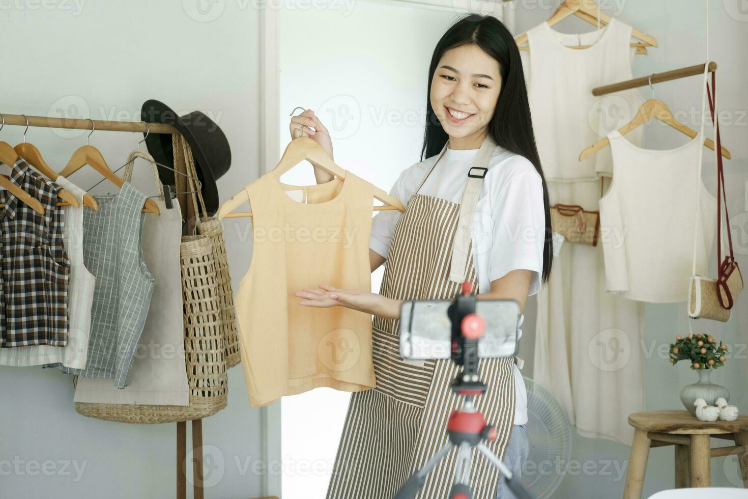 joven asiático mujer de negocios Moda blogger demostración paño con sonriente rostro. foto