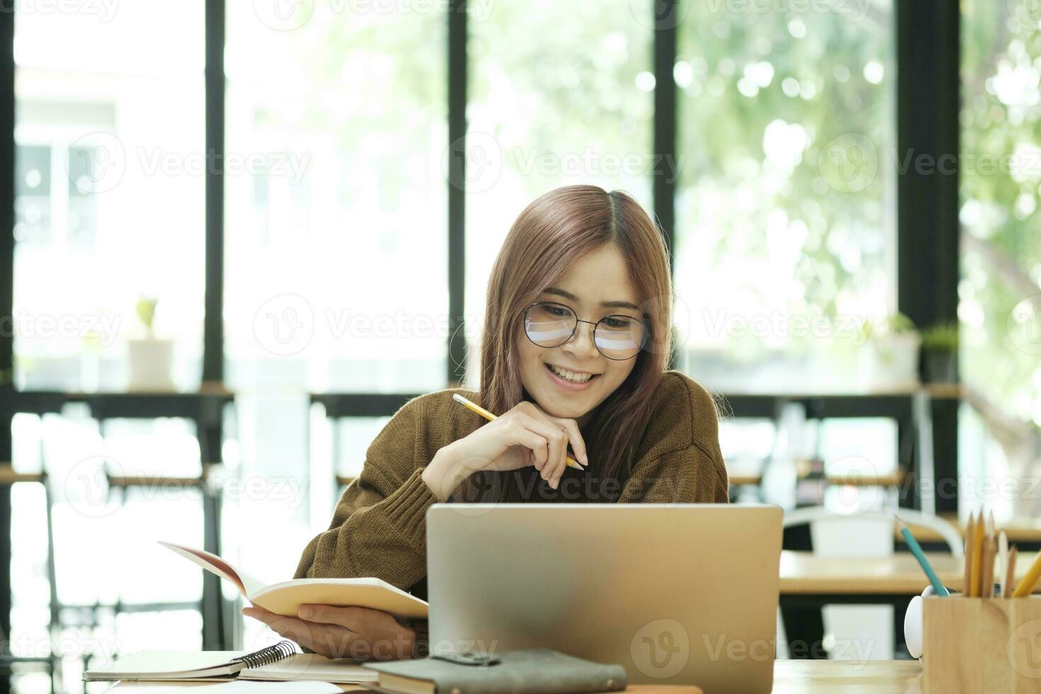Young collage student using computer and mobile device studying online. photo