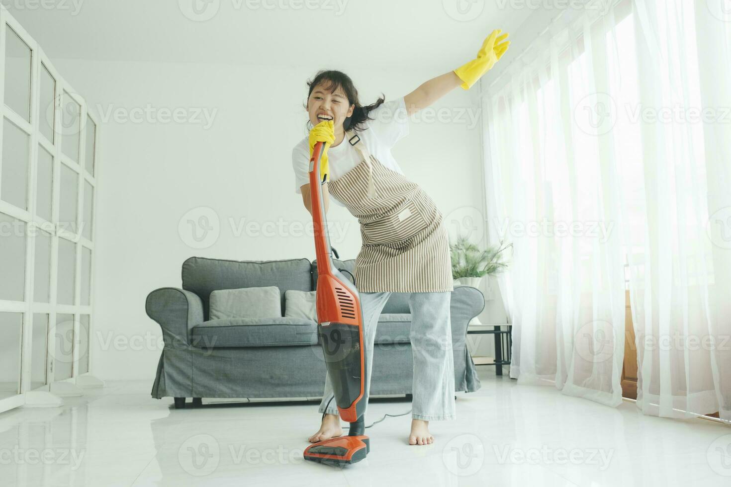joven mujer teniendo divertido mientras limpieza hogar. foto