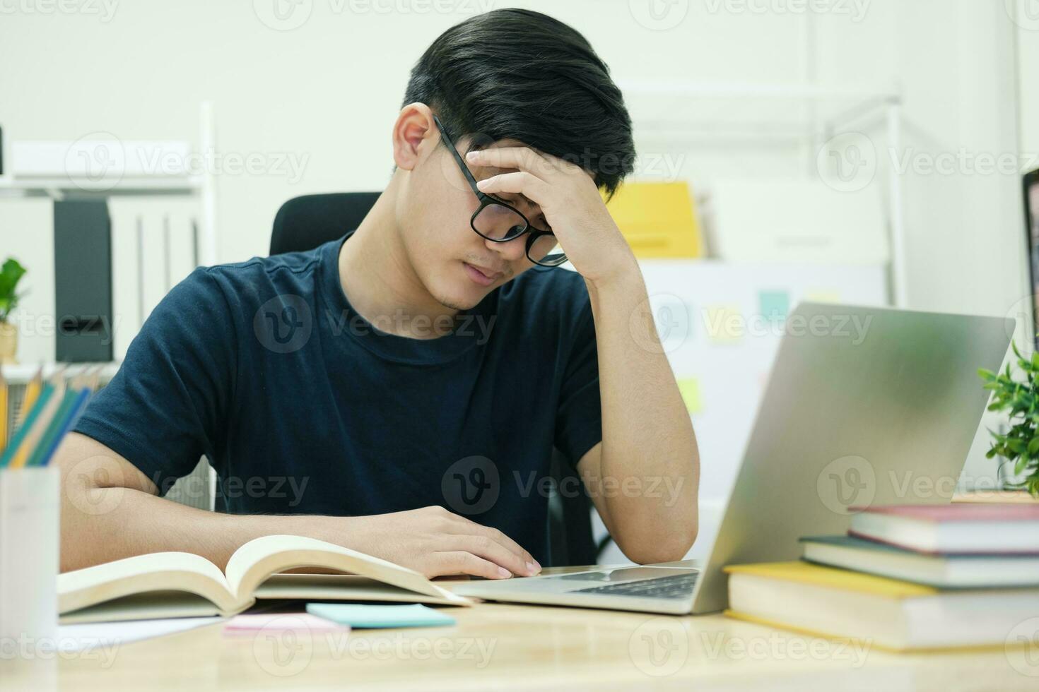 Exhausted businessman rubbing eyes while working at home. photo