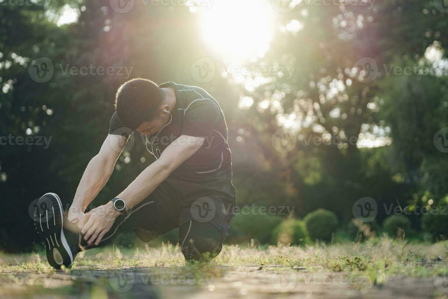 Athletic man in black sportswear doing fitness stretching exercises. photo
