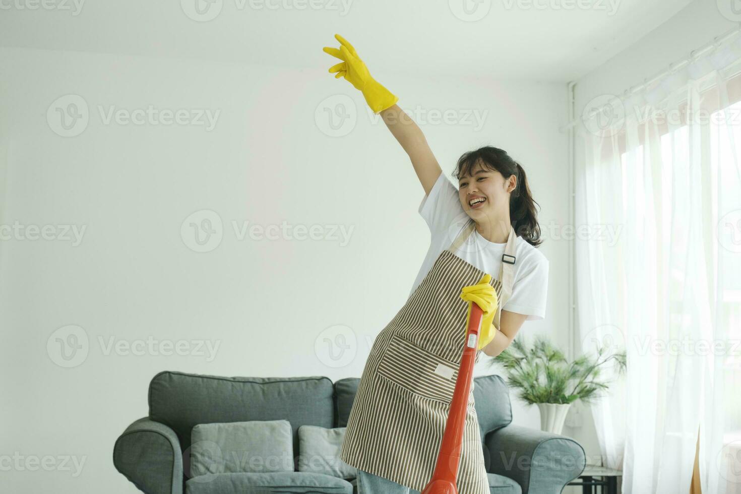 joven mujer teniendo divertido mientras limpieza hogar. foto