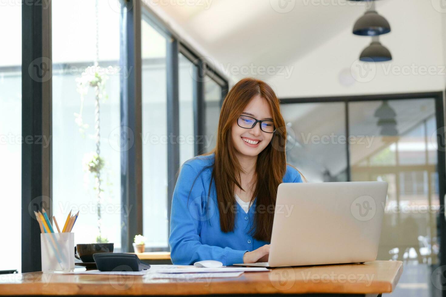 A female college student uses a computer to access the Internet for online learning. photo
