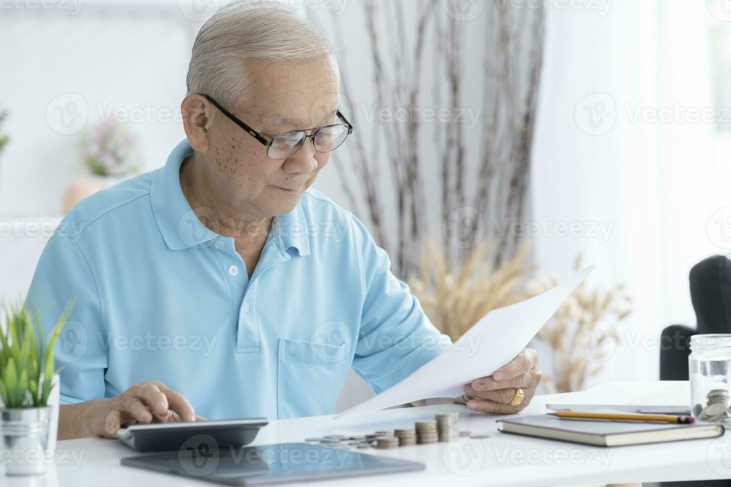 Senior man calculating taxes at home. photo