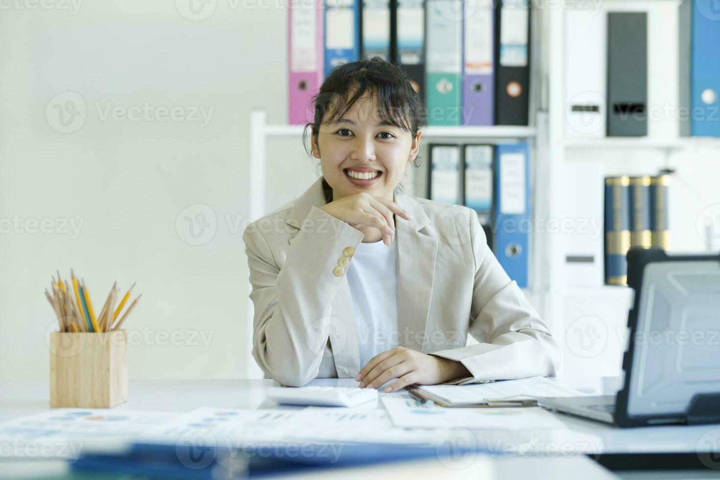 Yong Asian confident businesswoman is smiling and looking at camera photo