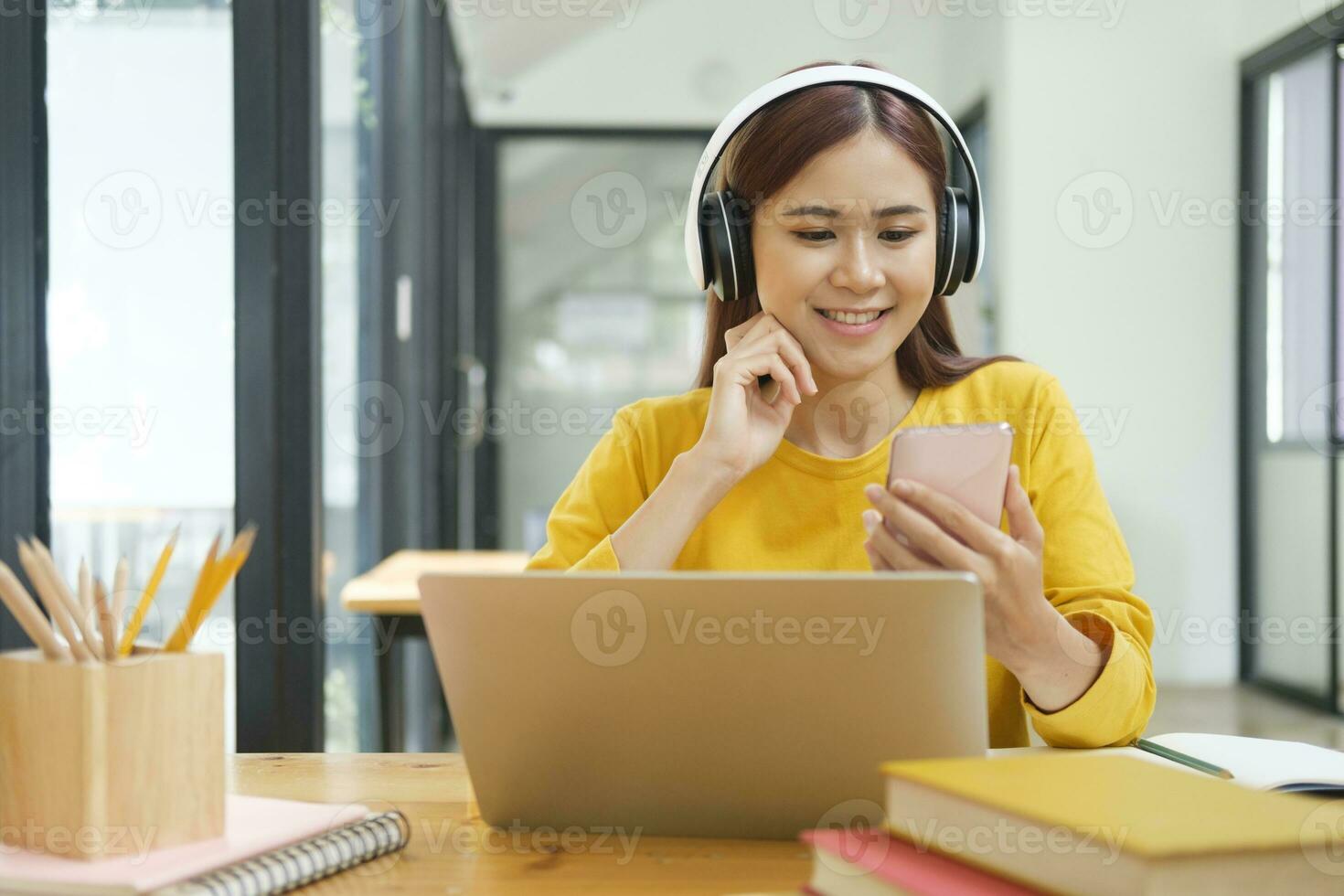 Young collage student using computer and mobile device studying online. photo