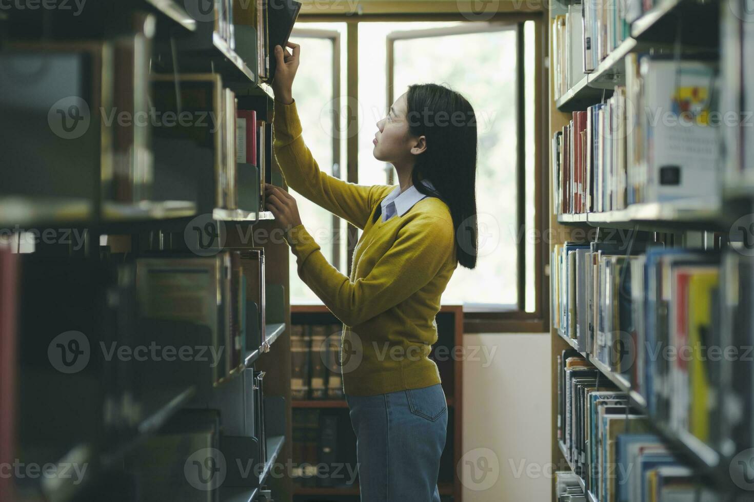 Student choosing and reading book at library. photo