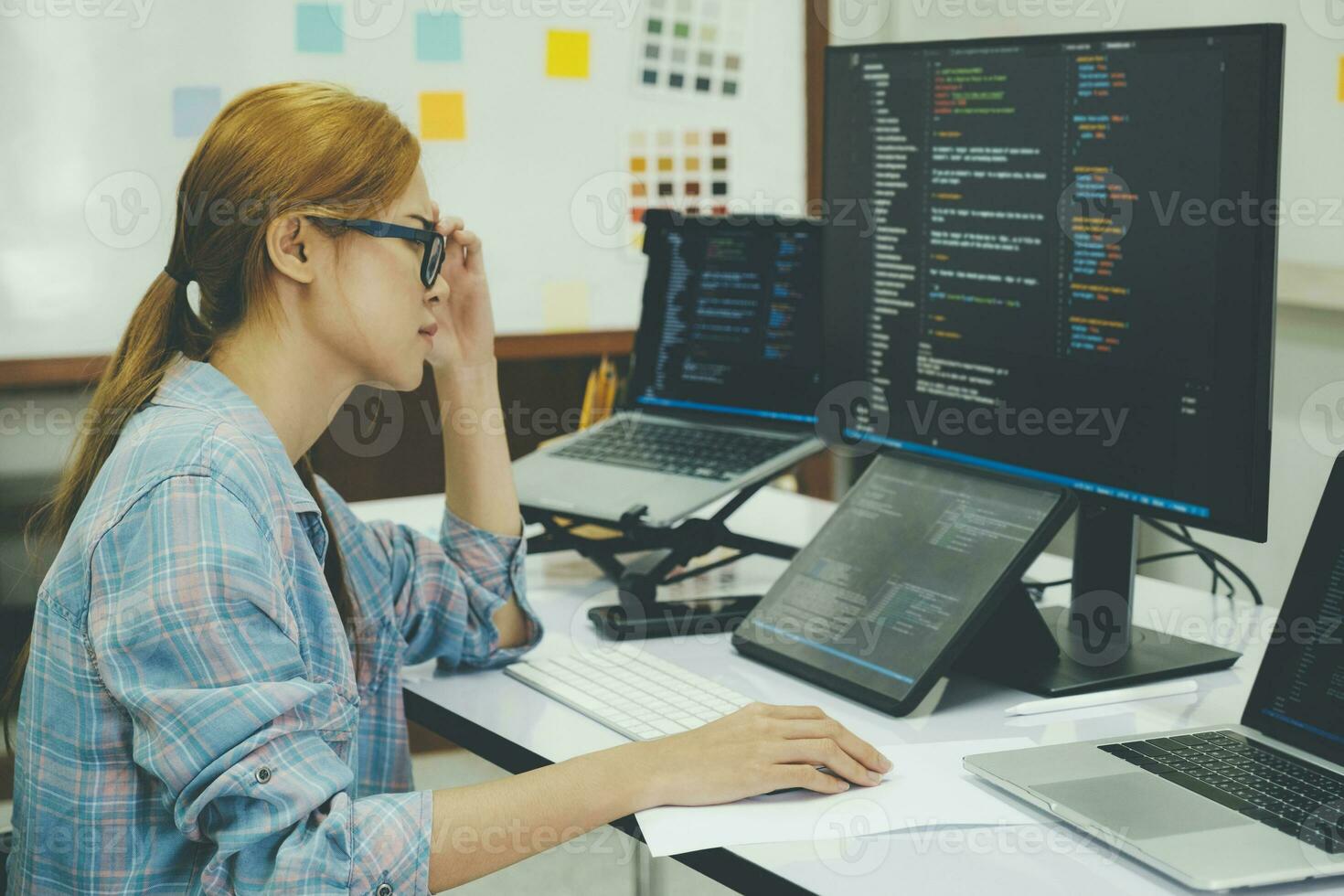 Young woman covering her face with the stress of work coding and programming software. photo