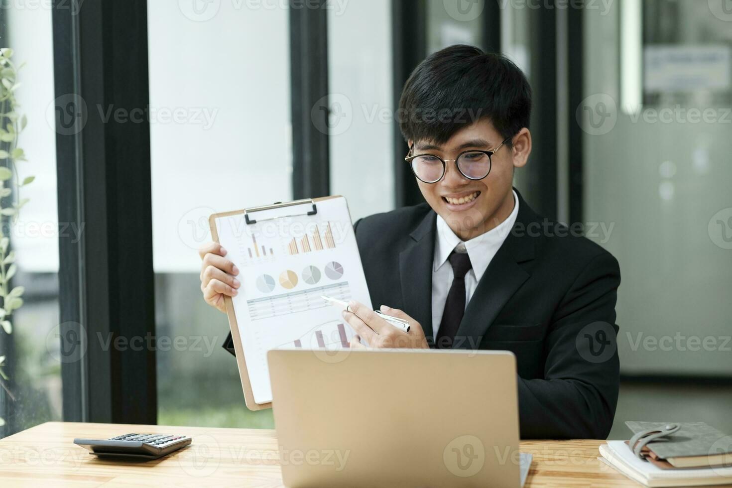 Businessman having video call with client and holding graph paper. photo