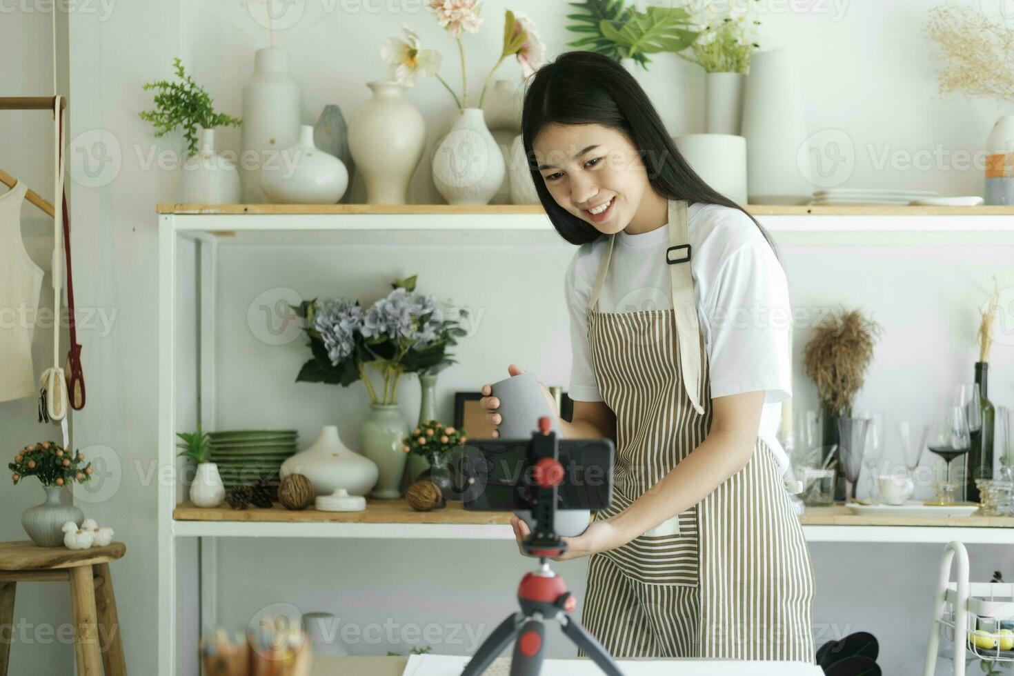 Young asian businesswoman fashion blogger showing ceramic products with smiling face. photo