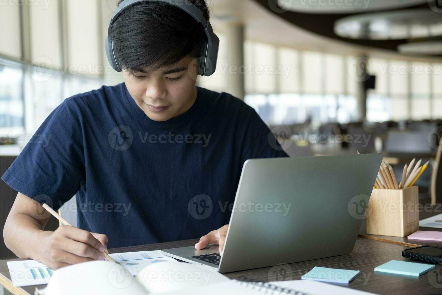 Young collage student using computer and mobile device studying online. photo