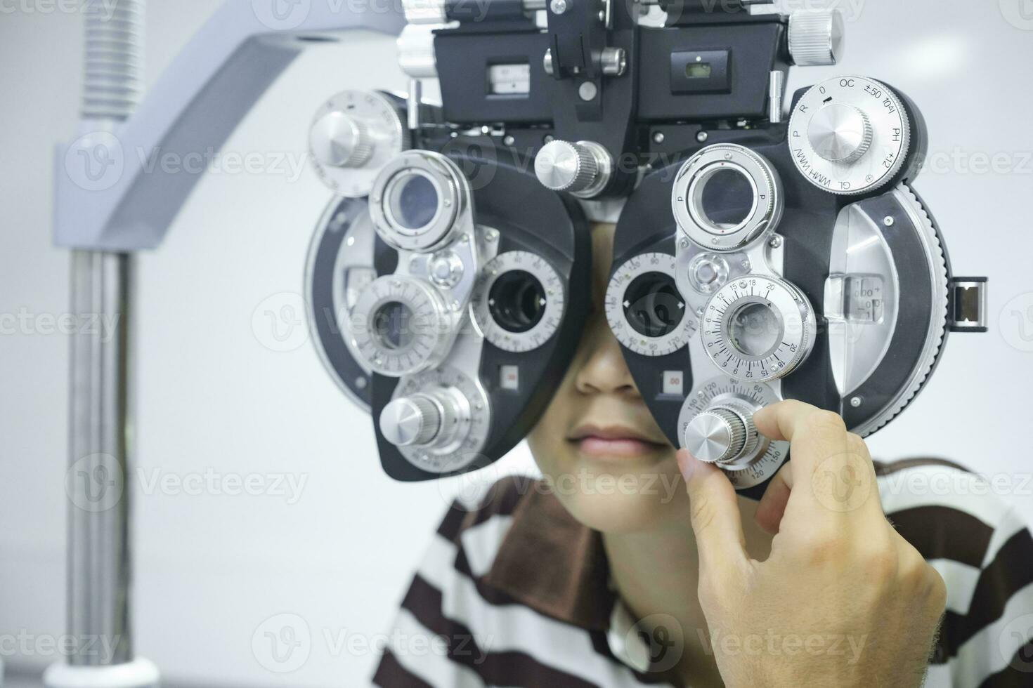 Young boy having eye test using phoropter. photo