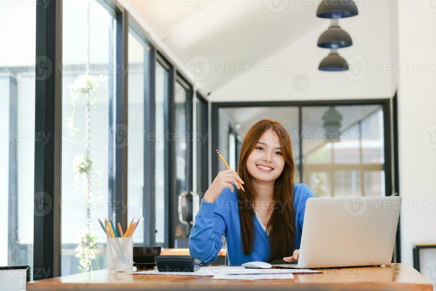 A female college student uses a computer to access the Internet for online learning. photo