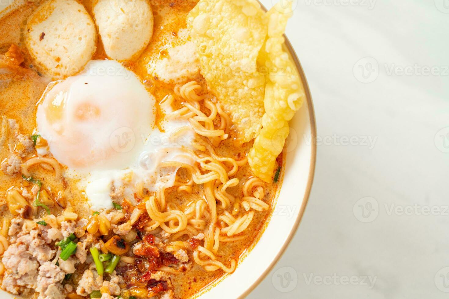 instant noodles with pork and meatballs in spicy soup photo