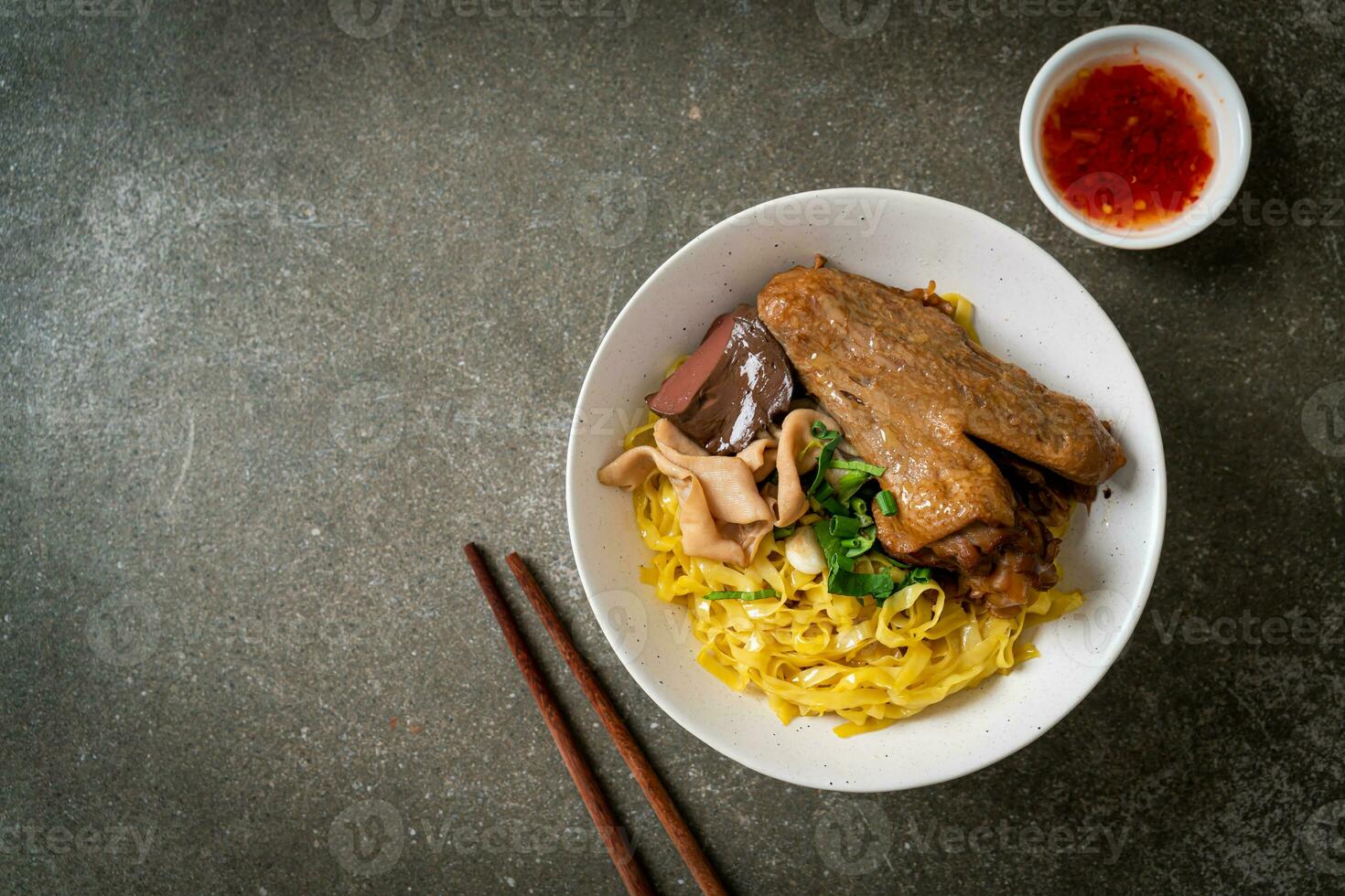 Egg noodles served dry with braised duck photo