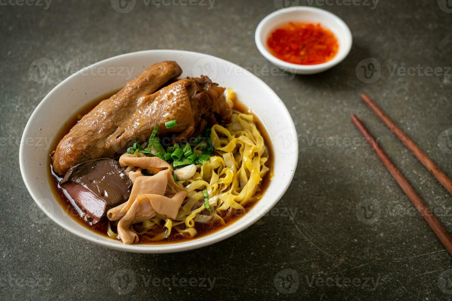 egg noodles with stewed and braised duck in brown soup photo
