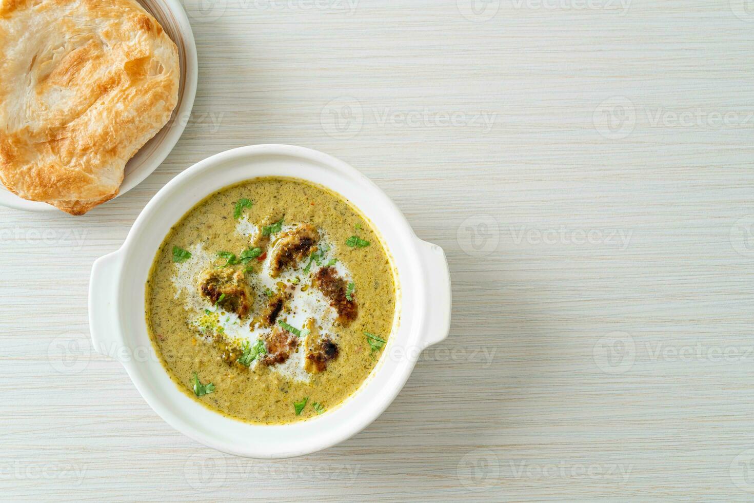 Afghani chicken in green masala curry or Hariyali tikka chicken hara masala with roti or naan bread photo