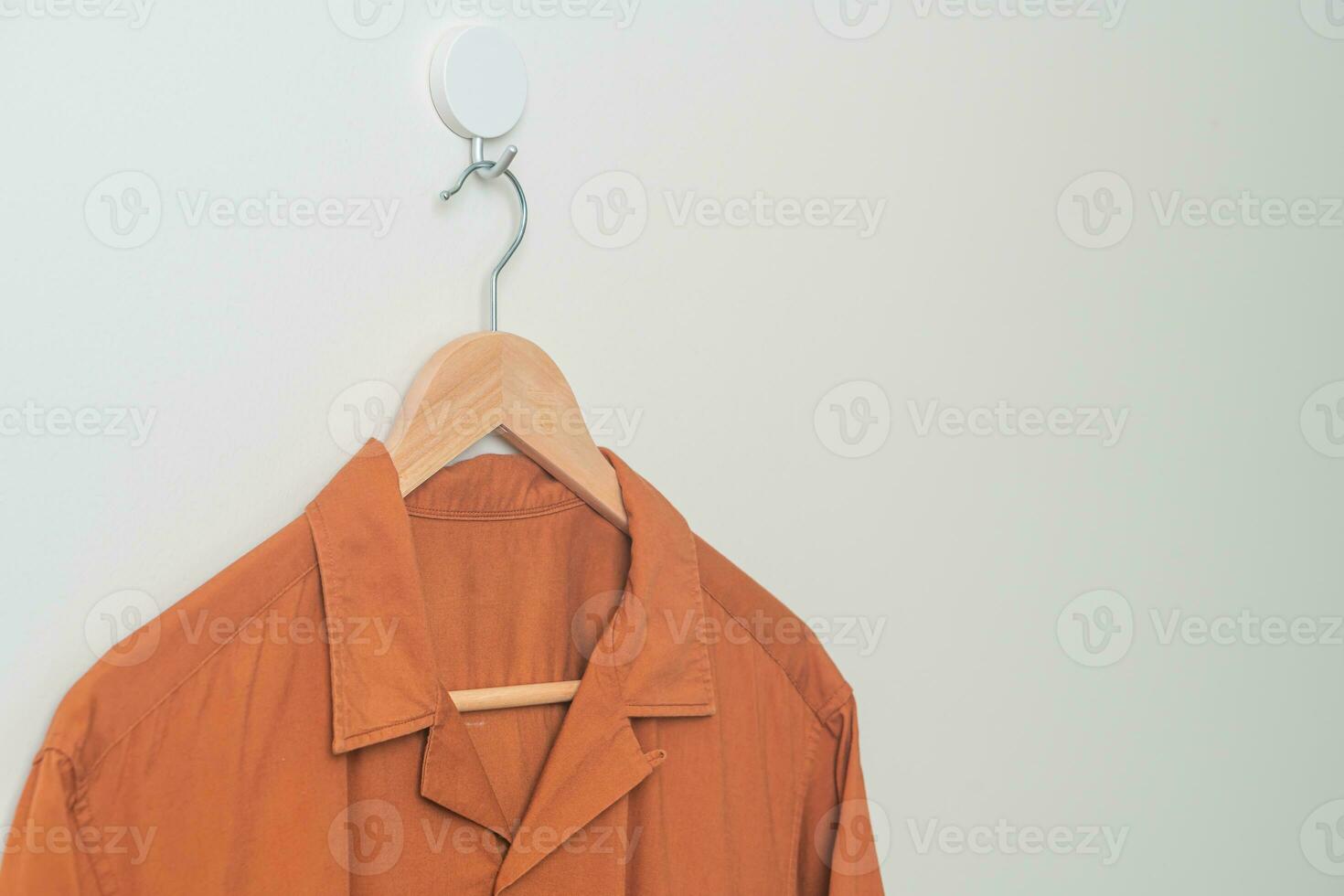 shirt with wood hanger on wall photo