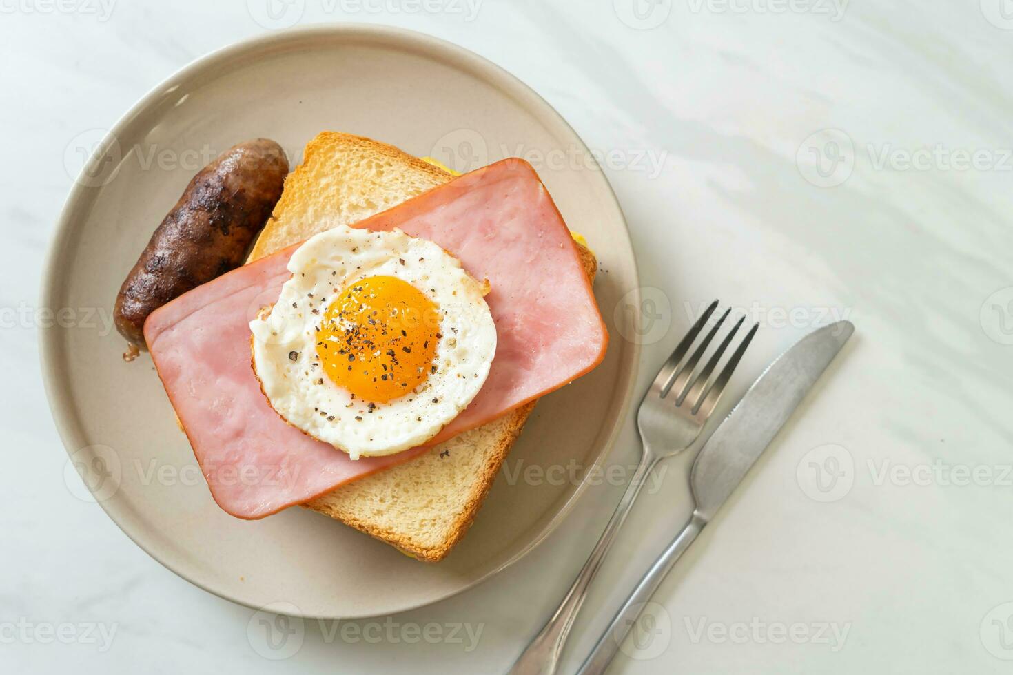 bread toasted cheese topped ham and fried egg with pork sausage photo