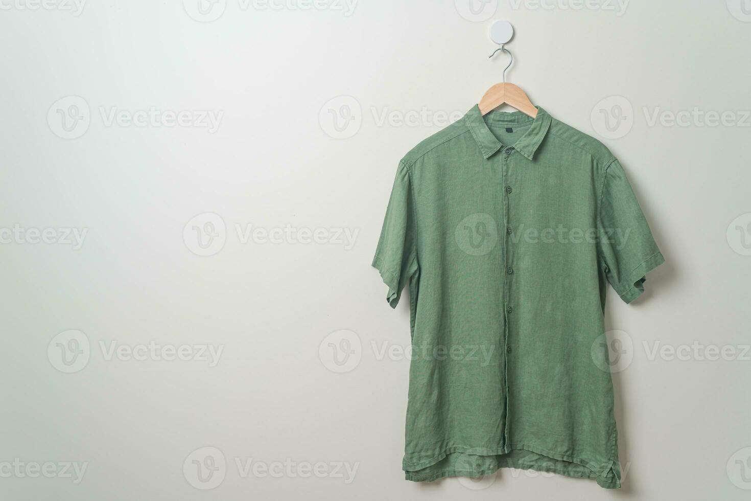 hanging shirt with wood hanger on wall photo