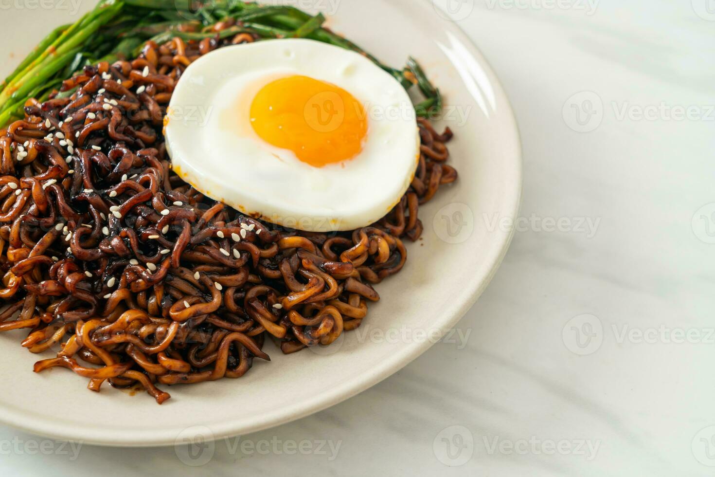 dried Korean spicy black sauce instant noodles with fried egg and kimchi photo