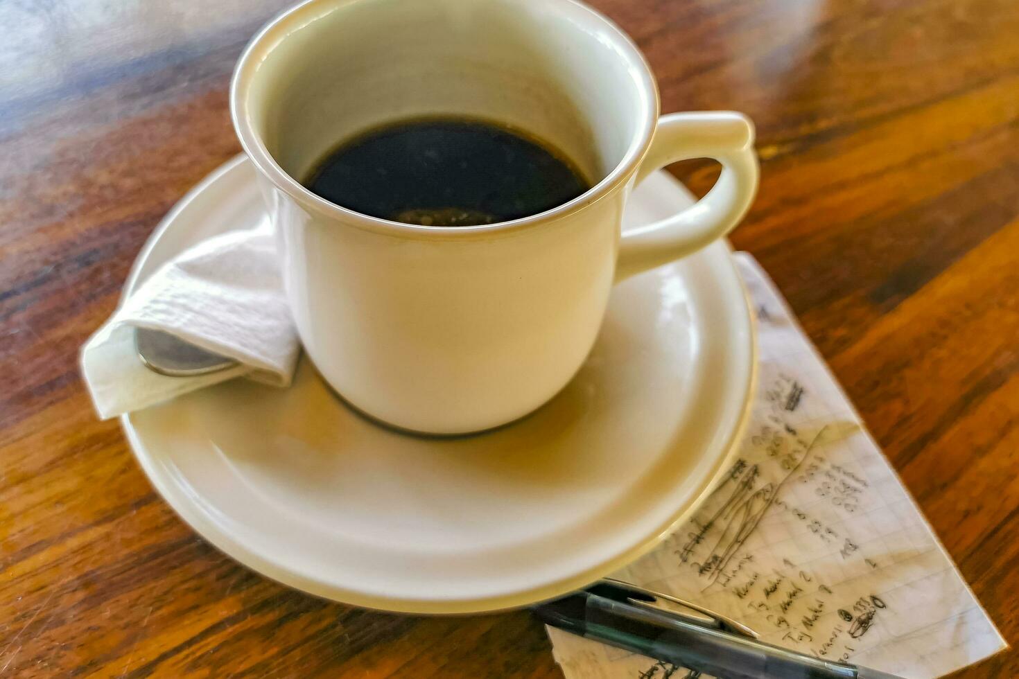 Cup of americano black coffee with notepad and pen Mexico. photo