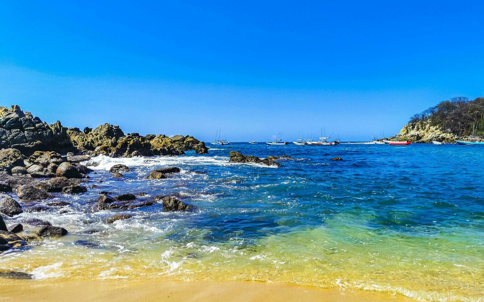 Beach sand blue turquoise water waves rocks panorama Puerto Escondido. photo