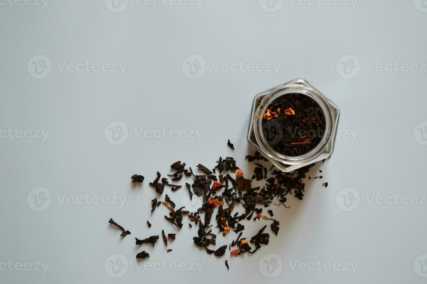 leaf tea with pieces of fruit in a jar, black tea, a jar of tea on a gray background, international tea day, banner photo