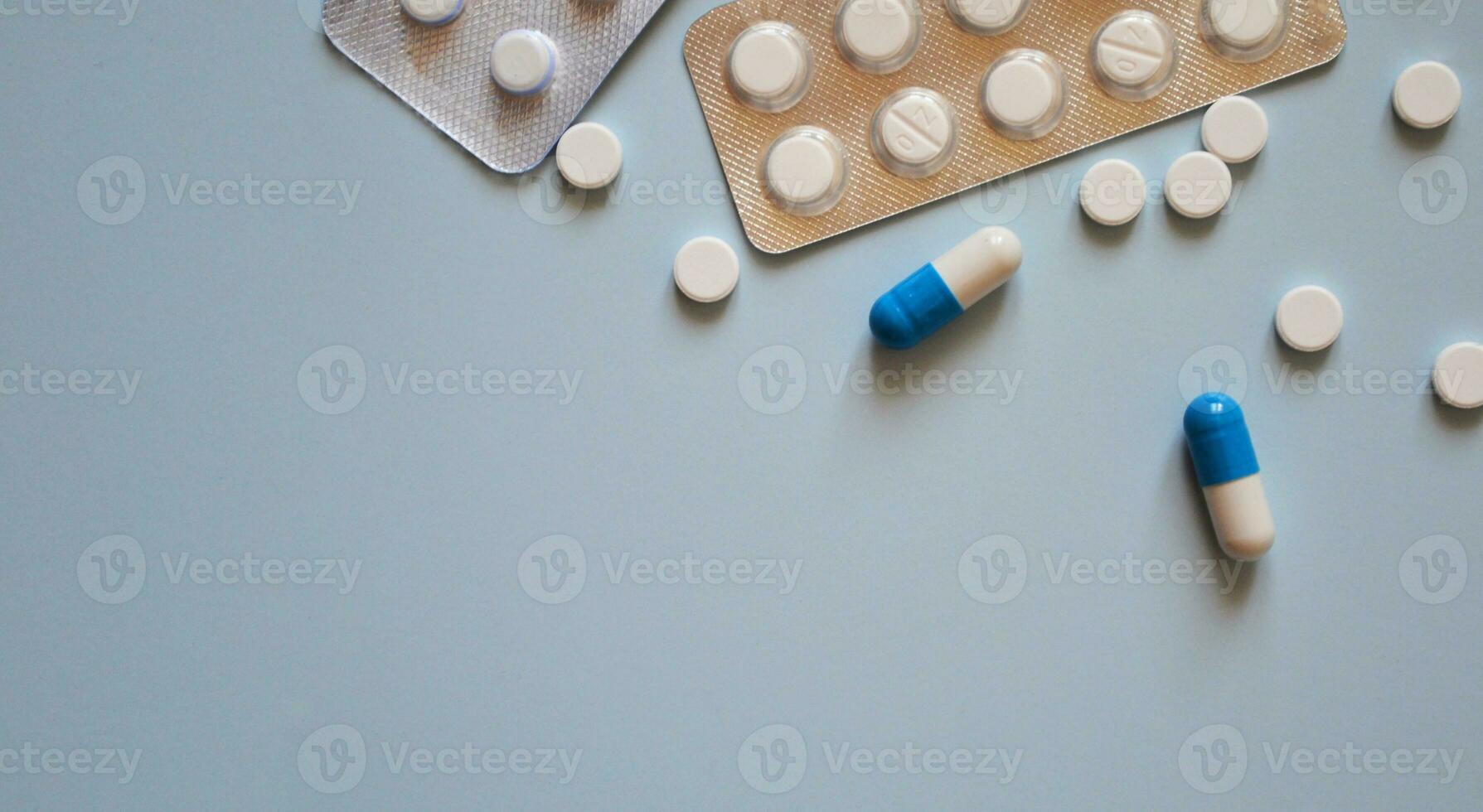 pills and pill packs on a blue background, medication, medical workers day, medical care, banner for hospital, place for text photo