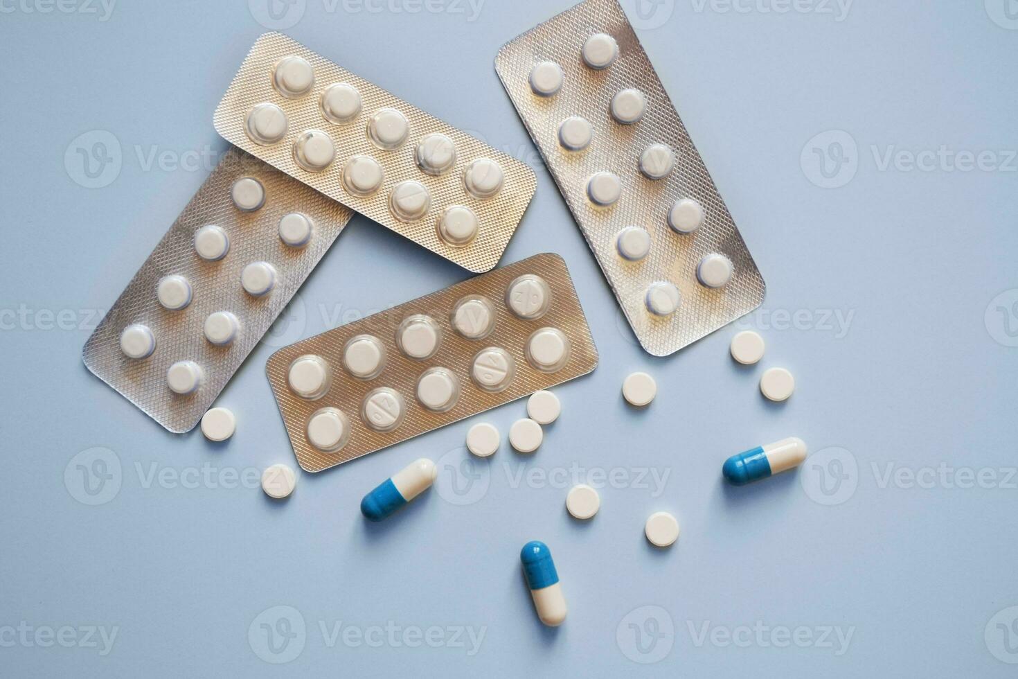 capsules, tablets and pill packs on a blue background, medication, medical workers day, medical care, banner for the hospital photo