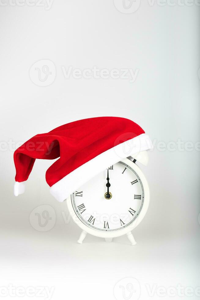 Vintage alarm clock in Santa Claus hat. photo