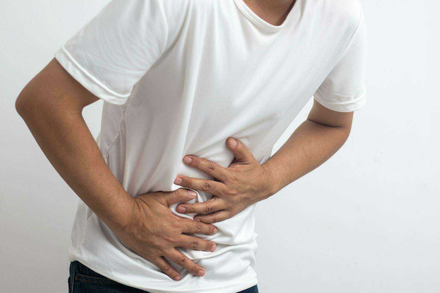 man having abdominal pain on white background photo