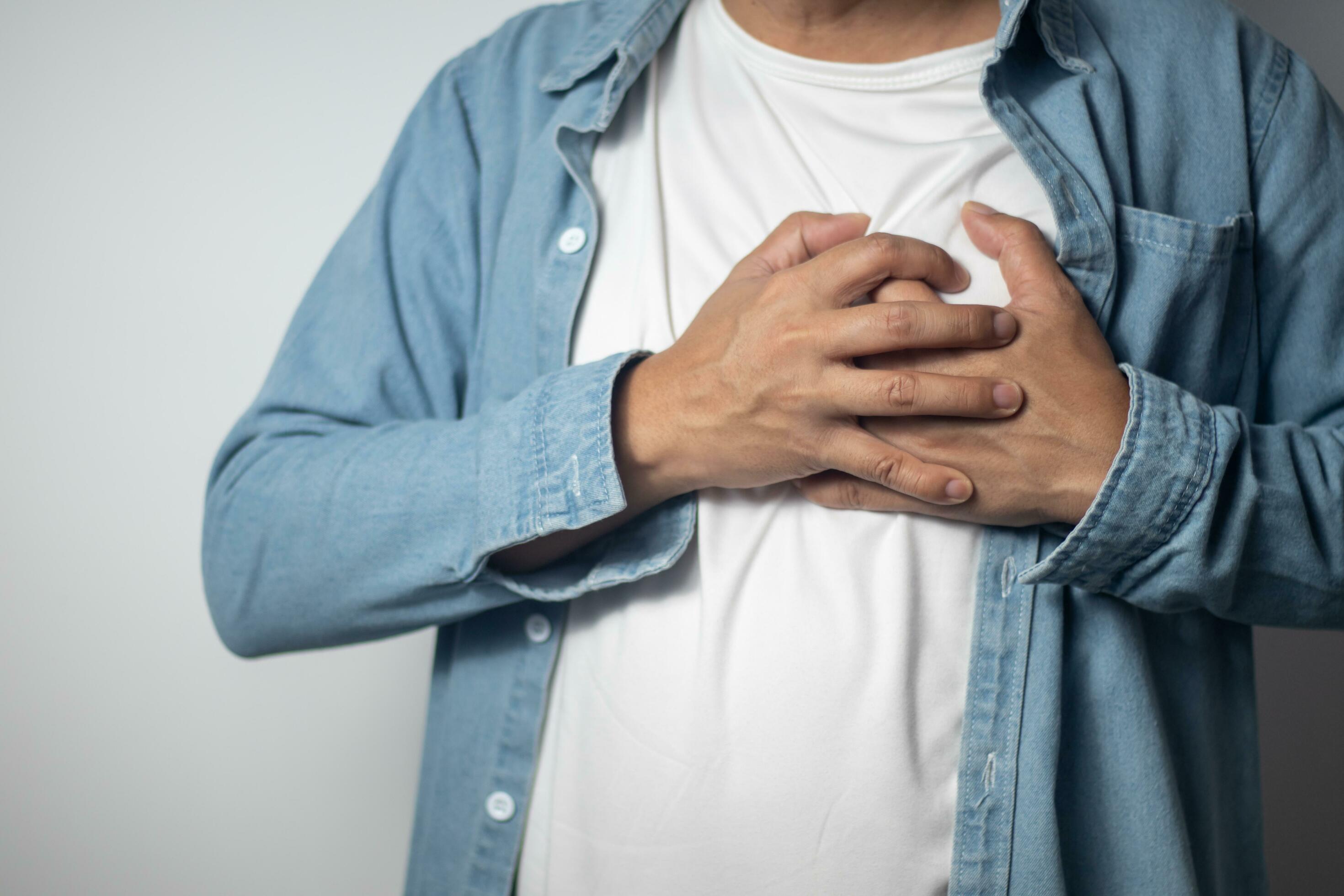 The man squeezed his left chest with both hands. 24799815 Stock Photo
