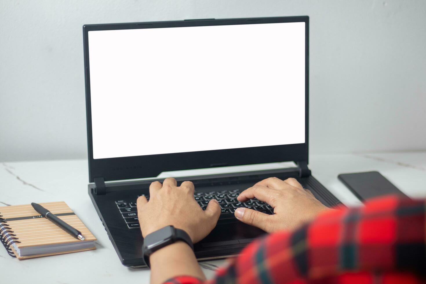 man's hands working on laptop in front of white photo