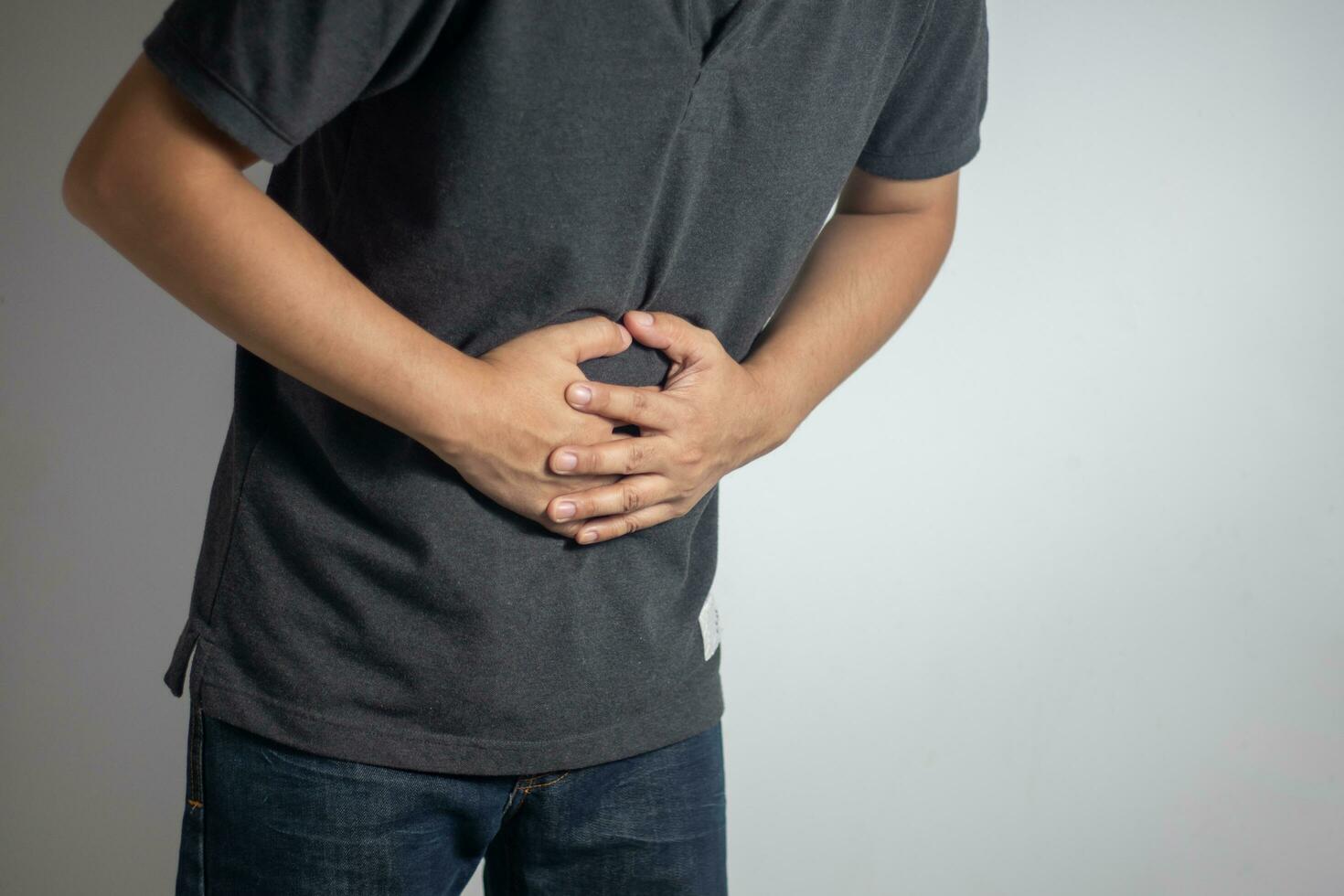 hombre teniendo abdominal dolor en blanco antecedentes foto