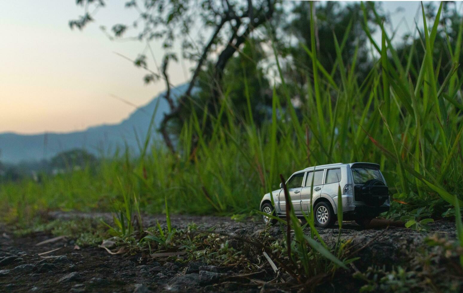 concepto para viaje y aventura. un juguete coche con un montaña ver en el temprano Mañana. foto