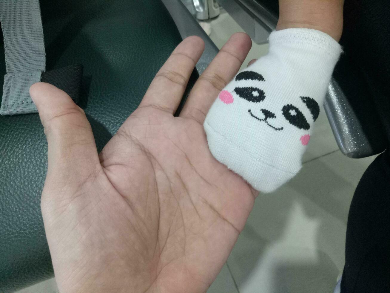 Photo of a baby's foot in a sock with a cute panda face on it