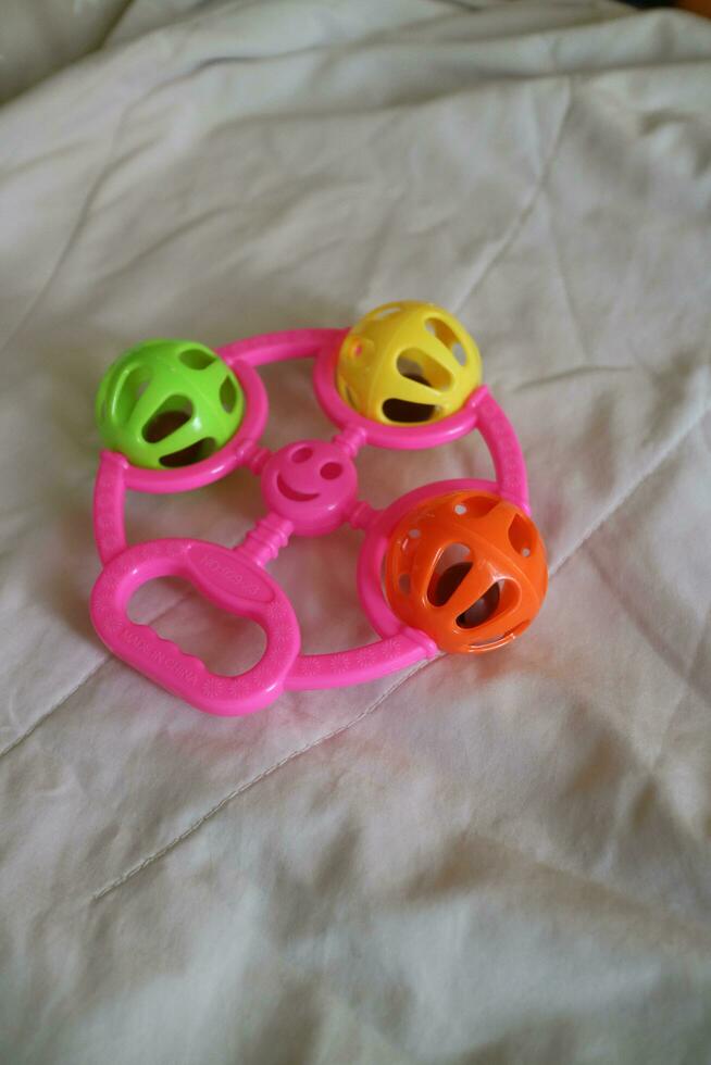 a colorful toddler toy that can make a tinkling sound with a pink handle photo