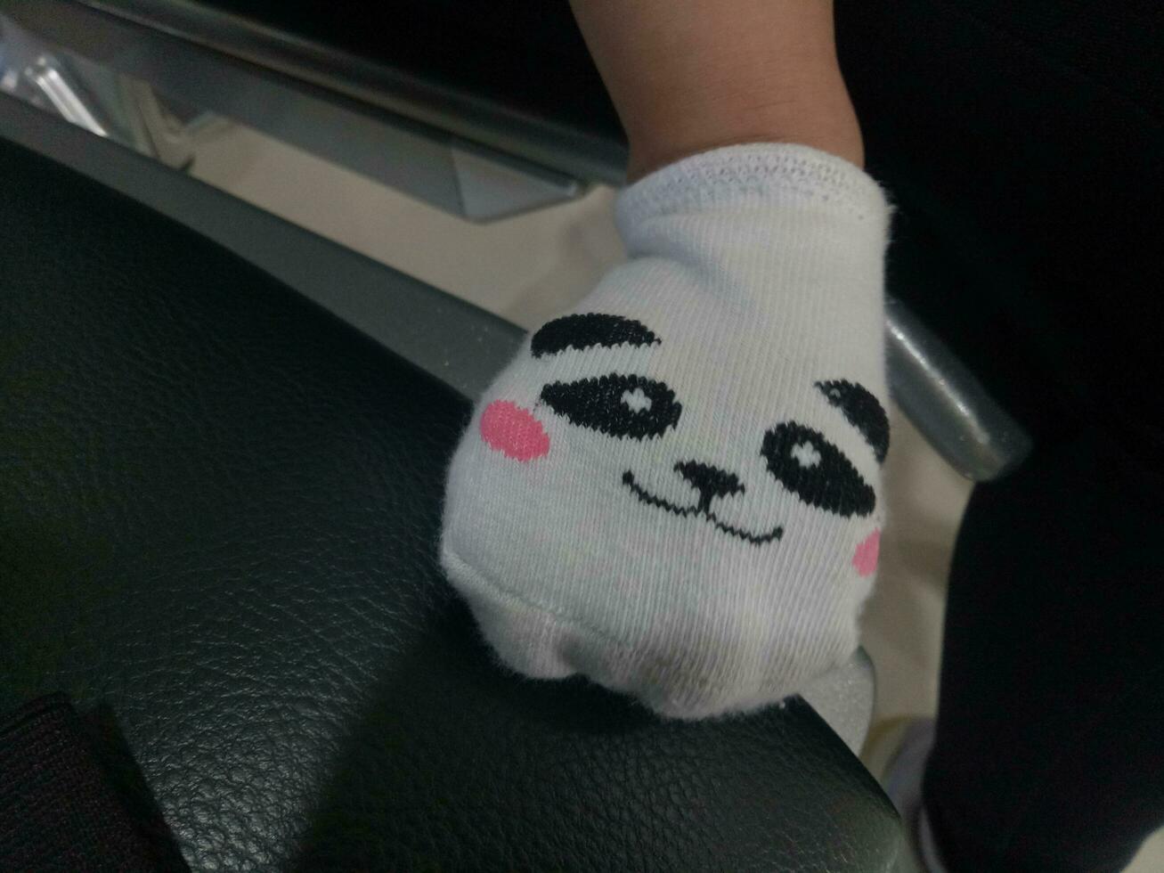 Photo of a baby's foot in a sock with a cute panda face on it